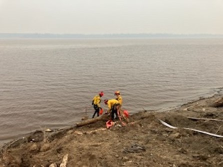 crews set up pump on the peace river along the paskwa fire perimeter